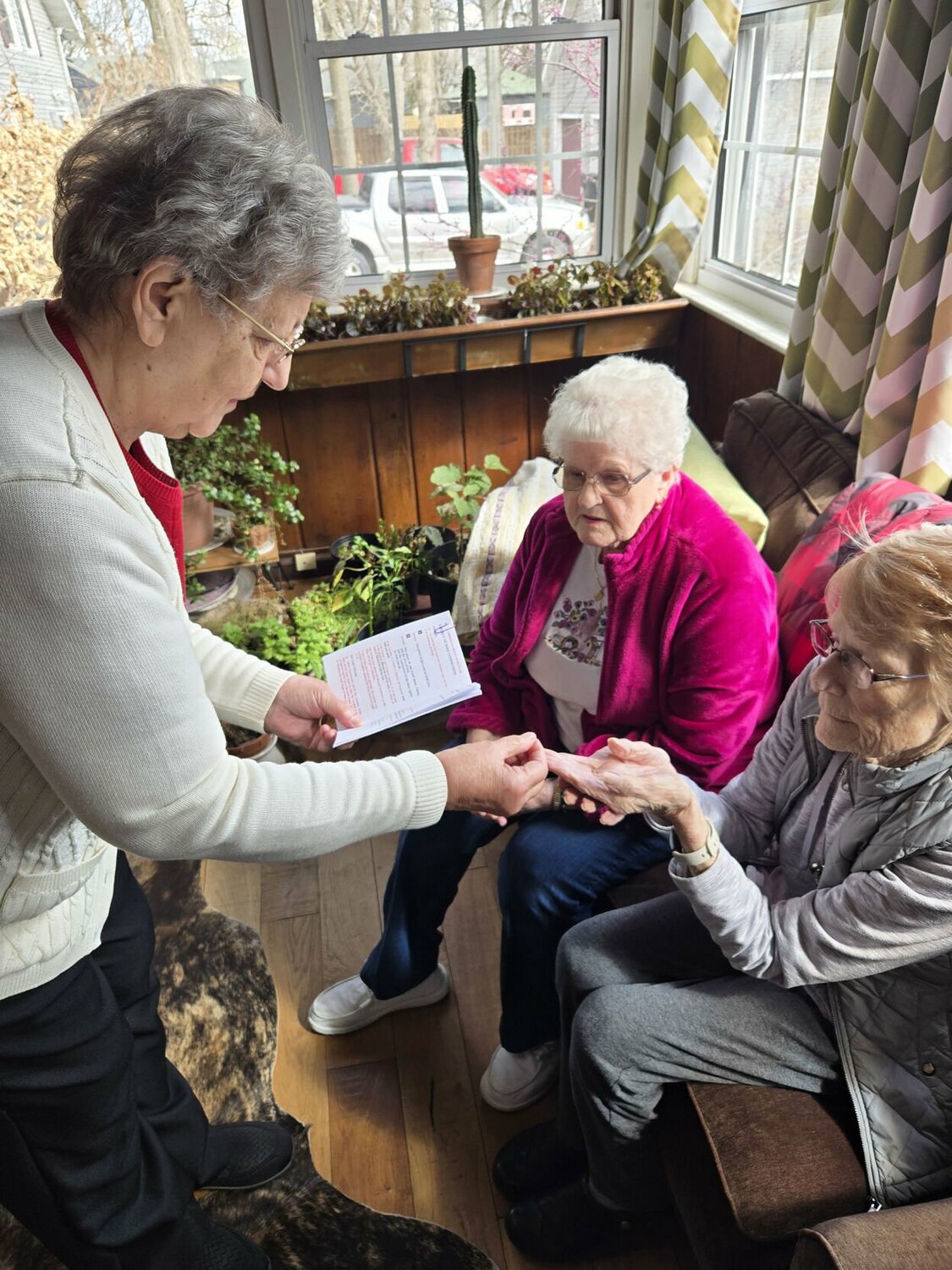 Woman receiving communion in her home.