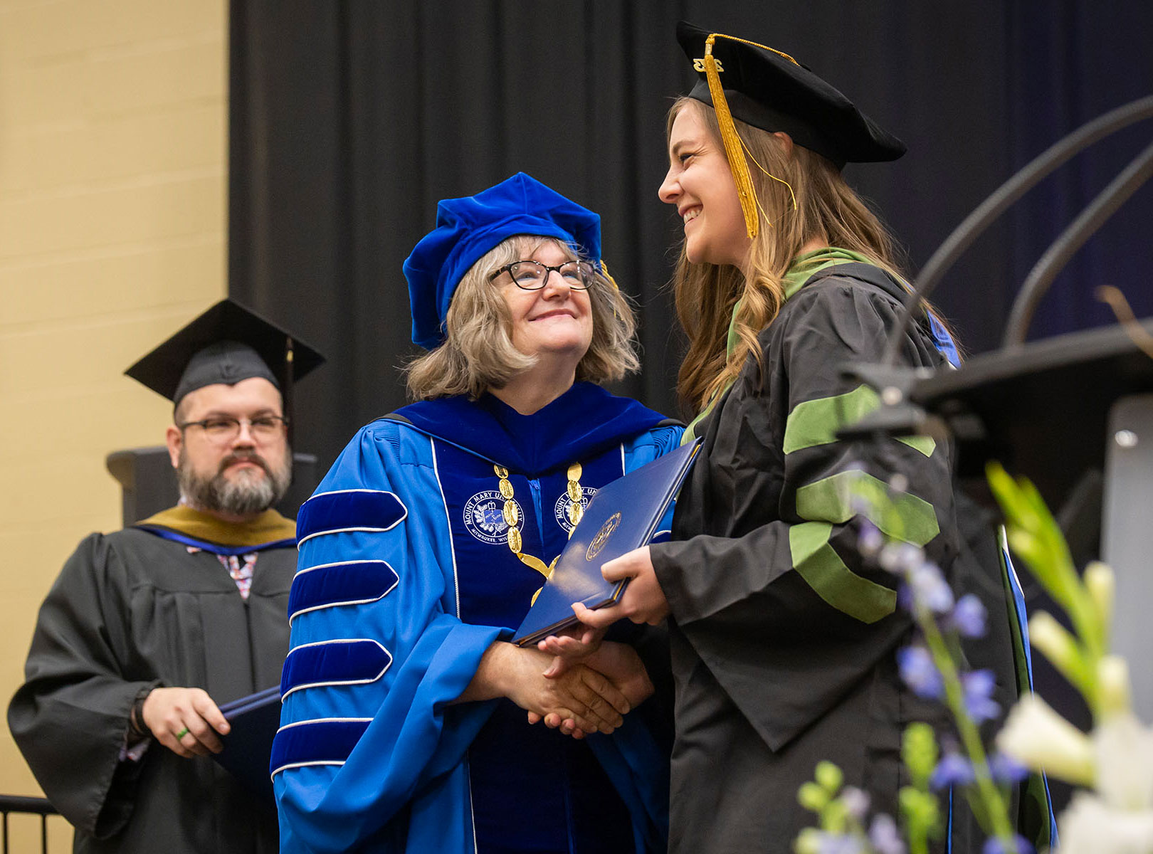 Mount Mary University President Dr. Isabelle Cherney congratulates a graduating student at commencement ceremonies.