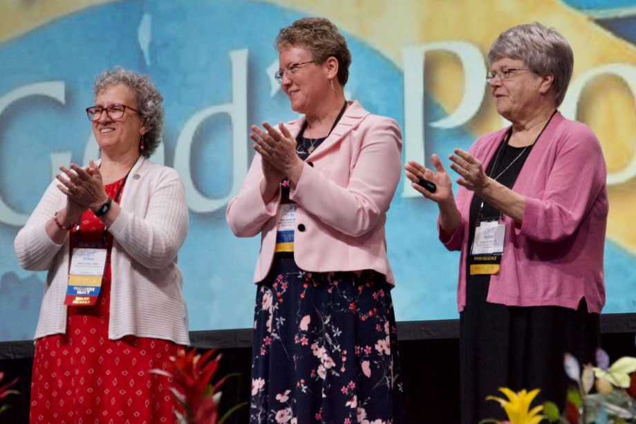 LCWR president-elect Sister Debra Sciano, left, stands on the LCWR assembly stage with president Sister Vicky Larson and past president Sister Kathy Brazda.