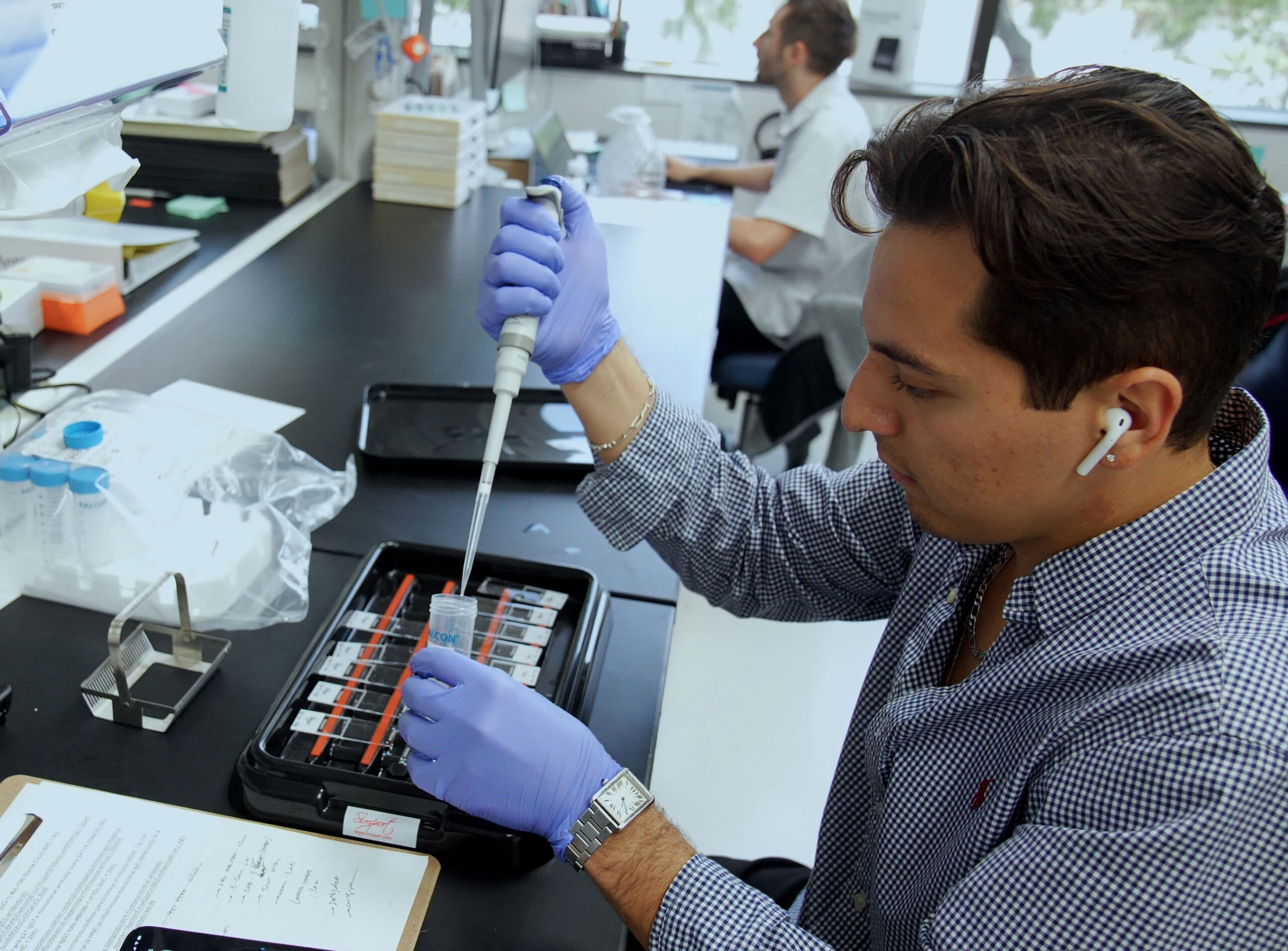 Scientist at lab bench with specimen. 