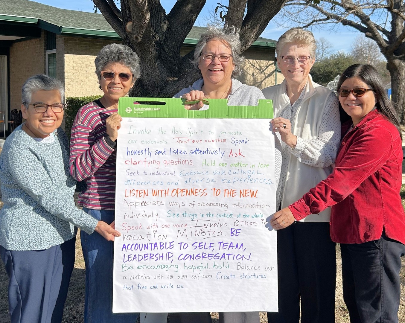 Five School Sisters of Notre Dame holding a newsprint pad.