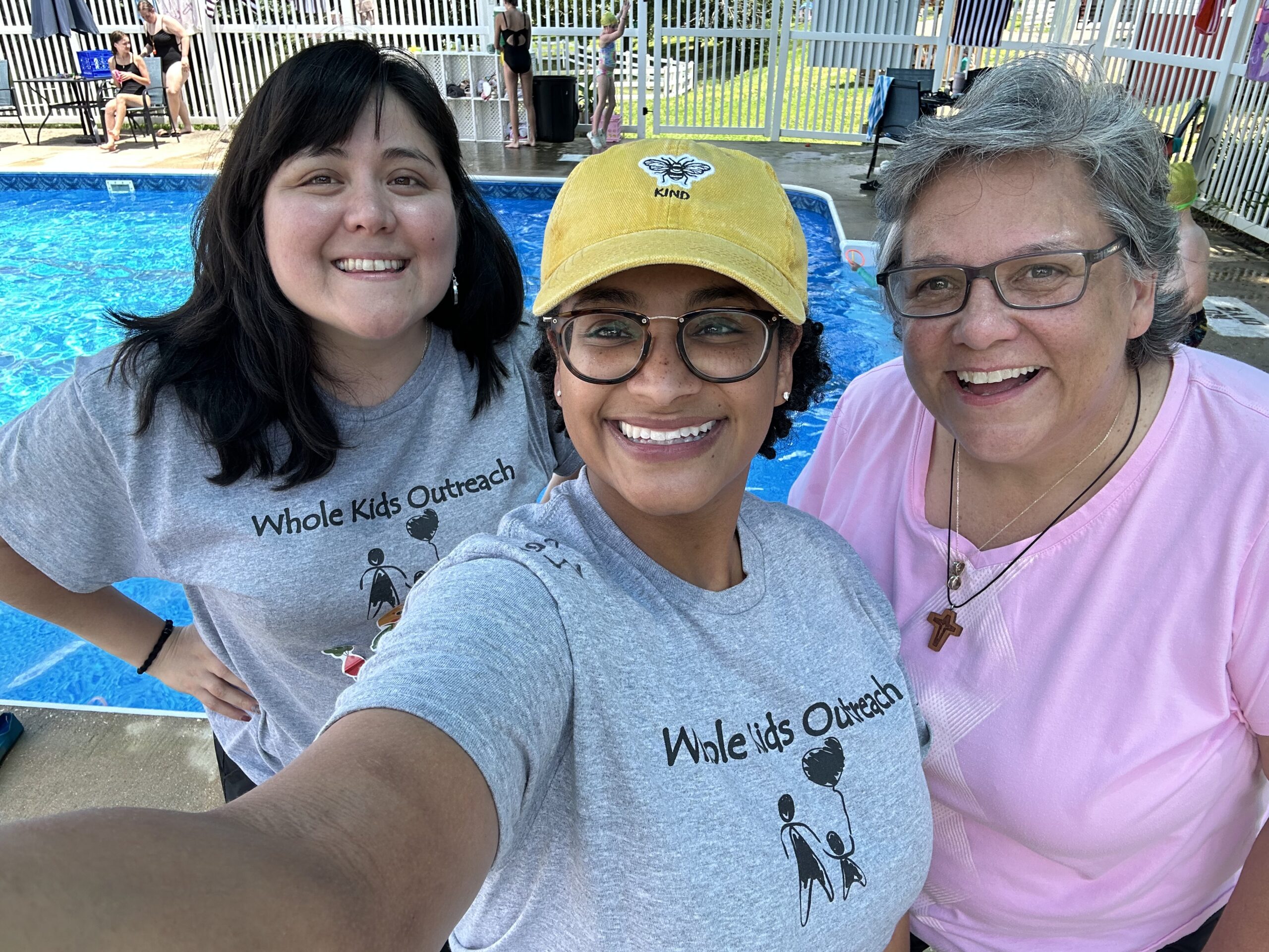 Volunteers enjoy a poolside moment with Sister Bridget at Camp Whole Kids.